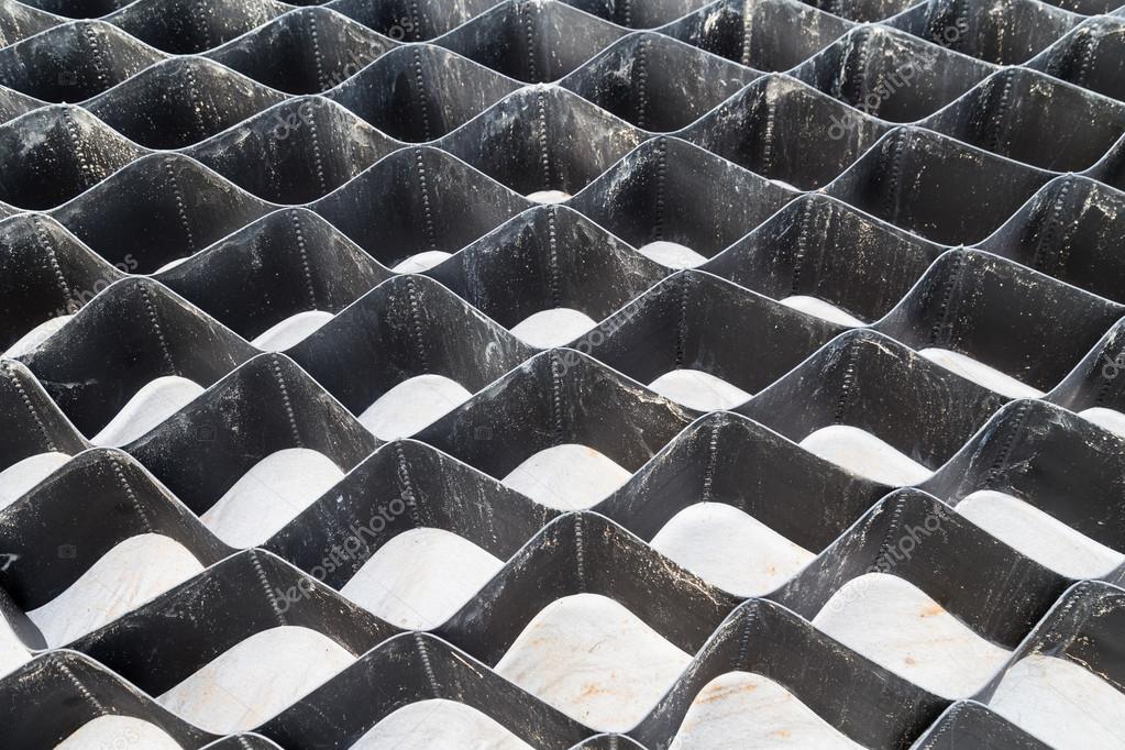 Close up on slope erosion control grids on steep slope. Stock Photo by