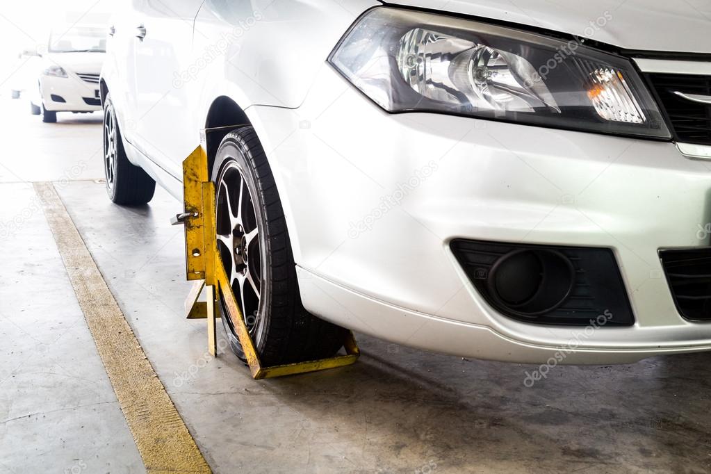 Car wheel clamped for illegal parking violation at car park