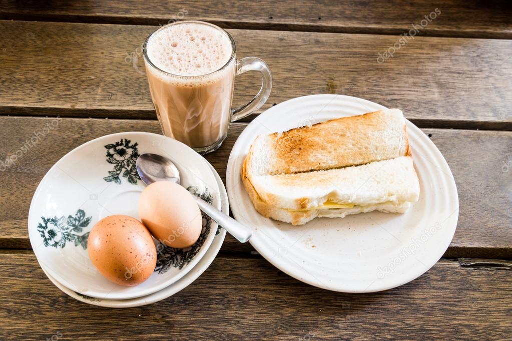 Popular Malaysian breakfast teh tarik, toast bread and half-boil