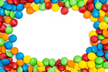 Frame of colorful chocolate candy on white background with space clipart
