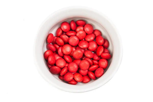 Översiktsvy skål med röda choklad godis i vit bakgrund — Stockfoto