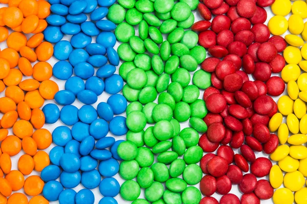 Stapel van kleurrijke chocolade snoepjes van kleur in rijen kolommen — Stockfoto