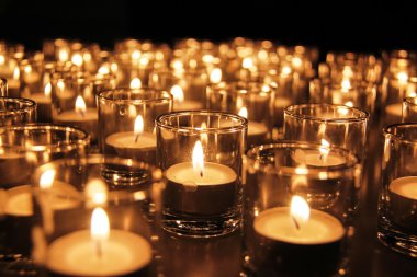 Tea lights in glass jar illuminates a dark surrounding
