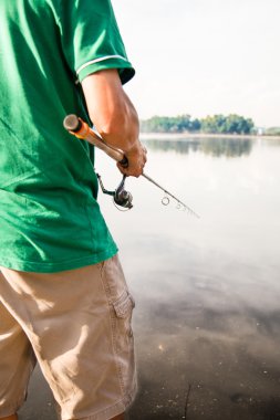 Man enjoying recreational fishing at a lake on a beautiful morning
