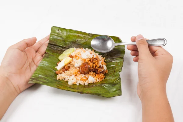 Personen äter enkel men äkta Nasi Lemak inlindad i bananblad — Stockfoto