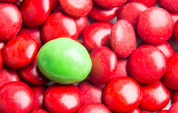 Concentre-se em doces de chocolate verde contra montes de doces vermelhos — Fotografia de Stock