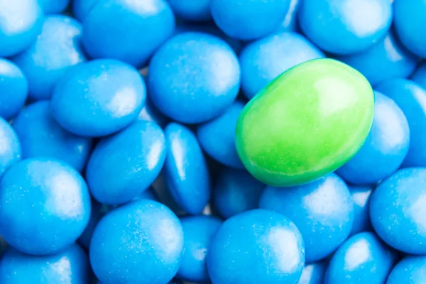 Сосредоточьтесь на зеленых шоколадных конфет против кучи голубых конфет — стоковое фото