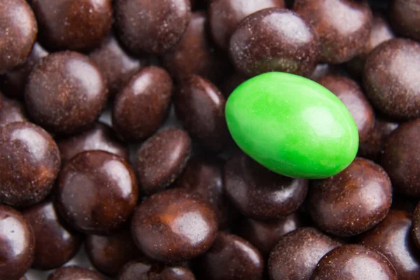Céntrate en caramelos de chocolate verde contra montones de caramelos marrones — Foto de Stock