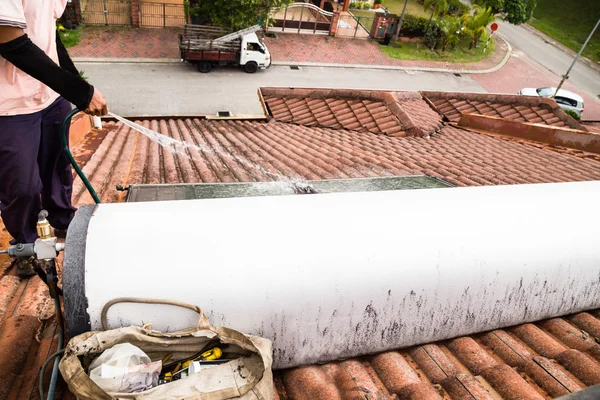 Werknemer zonneboiler op dak tijdens onderhoud reiniging — Stockfoto