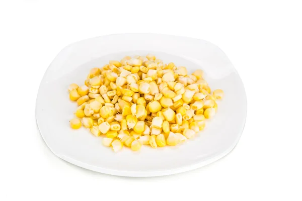 Färsk majs majskorn på plattan mot vit bakgrund — Stockfoto