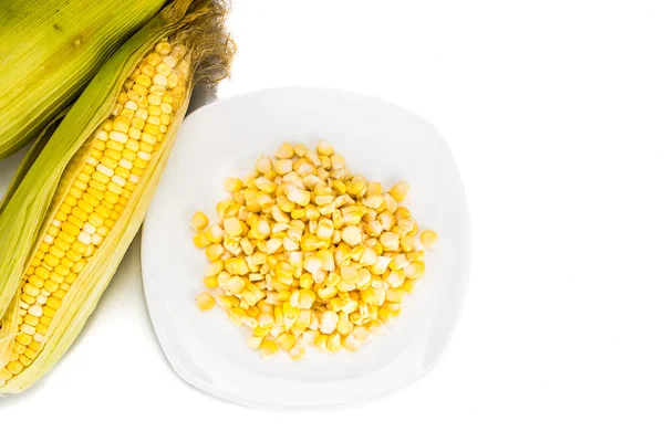 Вид сверху на свежий кукурузный початок и зерна кукурузы на тарелке — стоковое фото