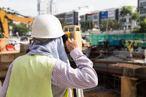 Ingeniero que opera el instrumento de nivel automático volcado en const — Foto de Stock