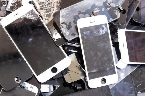 Stack of damaged smart phone body and cracked LCD screen — Stock Photo, Image