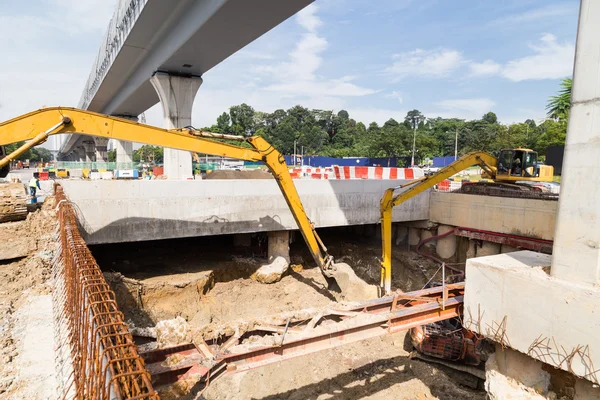 Graafmachines graven van grond in de bouw van de tunnel onderdoorgang in bouwplaats — Stockfoto