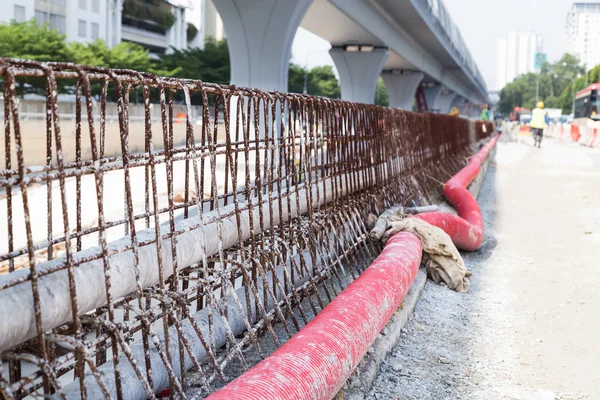 PVC, gegolfde kunststof buizen, betonstaal concrete scheidingslijn in weg bouwplaats — Stockfoto