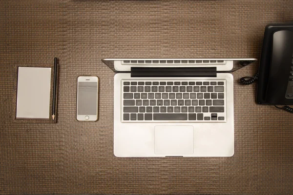 Gadgets esenciales teléfono, portátil y bloc de notas para la oficina móvil — Foto de Stock