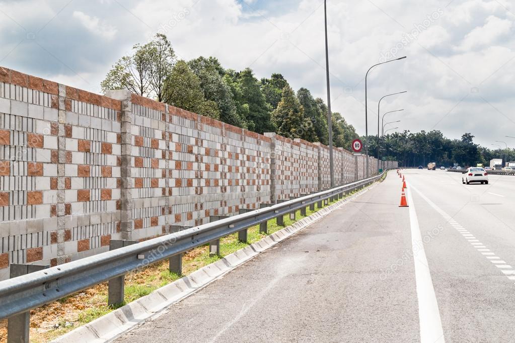 Concrete noise barrier wall along busy noisy highway