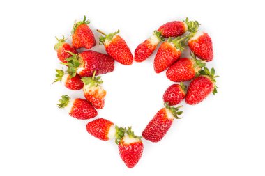 Heaps of strawberries form heart shape on white background