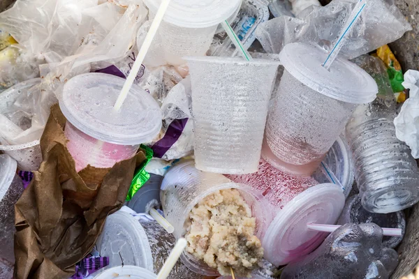 Екологічно чисті небіорозкладні контейнери з ПВХ, соломинки та незакінчена їжа в сміттєвому баку — стокове фото