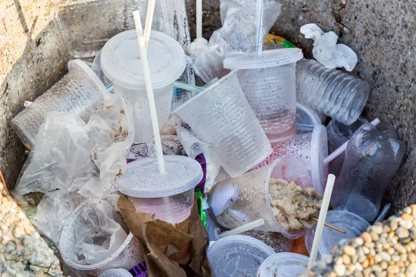 Životního prostředí nepřátelské biologicky Pvc nádoby, brčka a nedokončený potraviny v odpadkového koše — Stock fotografie
