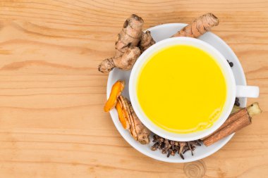 Healthy turmeric milk tea with ginger, cinnamon, cloves, black pepper