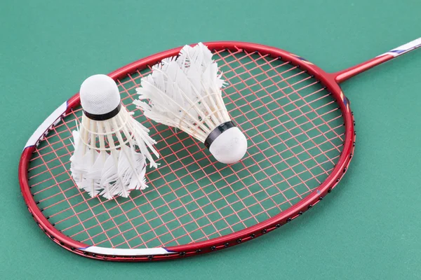 Dois worned fora badminton shuttlecock com raquete no verde tribunal — Fotografia de Stock