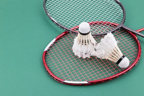 Dois worned fora badminton shuttlecock com raquete no verde tribunal — Fotografia de Stock