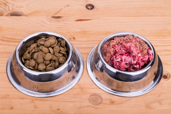 Choice of raw meat or kibbles dog food in bowl — Stock Photo, Image