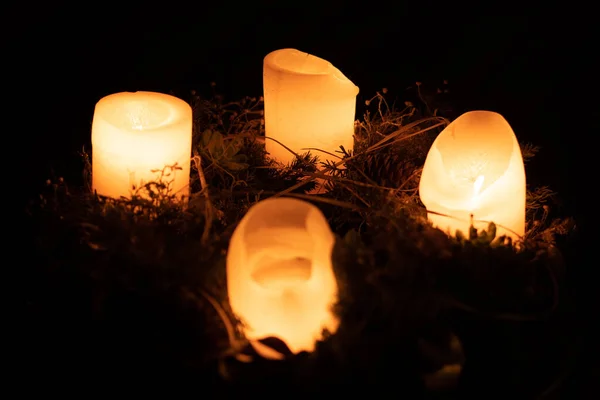 Горящие свечи на зарождении в темноте — стоковое фото