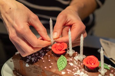 Mumlar, yapraklar ve çiçeklerle bir doğum günü pastası hazırlıyorum.