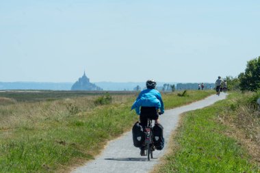 Fransa 'nın Eurovelo kentindeki Brittany kıyısı boyunca Mont-Saint-Michel' e doğru bisiklet sürüyor..