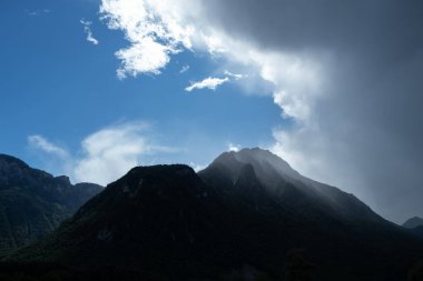 Fırtınadan kısa bir süre sonra atmosfer. Mavi gökyüzü ve tepenin etrafında kara bulutlar