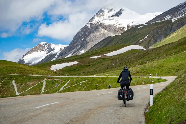 Bir bisikletçi İsviçre 'nin Albula caddesinden yüksek dağlık araziye doğru tırmanıyor.
