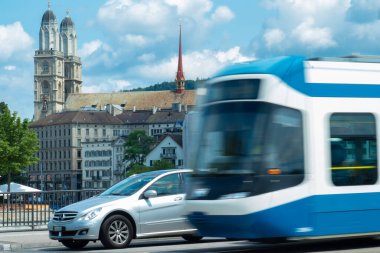 Zürih, İsviçre - 13 Temmuz 2019: Grossmuenster Kilisesi önünde bir tramvayı sollayan tramvay