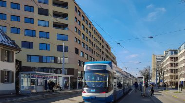 Zürih, İsviçre - 9 Mart 2016: Kentsel konut projesi Kalkbreite. Modern binaların önünden bir tramvay geçiyor..