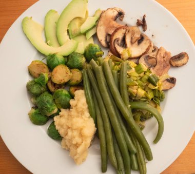 Beyaz tabakta servis edilen lezzetli sebzeler..