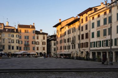 İtalya 'nın Udine kentindeki merkez meydanı Giacomo Matteotti' de akşam güneşini yansıtan tarihi konut binaları bulunmaktadır..