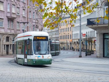 Bahnhofstrasse, Almanya 'nın Augsburg eyaletinde yer alan tarihi bir caddedir. Sonbahar renklerinde ağaçlar, eski binalar ve Koenigsplatz 'a yaklaşan bir tramvay durumu.
