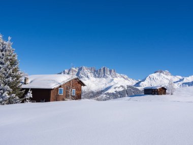 İsviçre 'nin Praettigau bölgesinde zirvelerle çevrili dağlık dağ manzarasının ortasındaki güzel ahşap kulübe. Raetikon kar ayakkabısı panoramik izinden görüntüle.