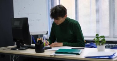 Ofis çalışanı not alıyor, hata yapıyor, buruşturup çöpe atıyor.