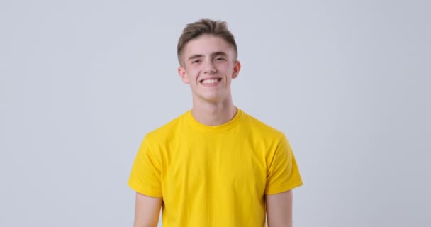 Homem feliz em camiseta amarela mostrando sinal shaka, sinal de chamada — Vídeo de Stock