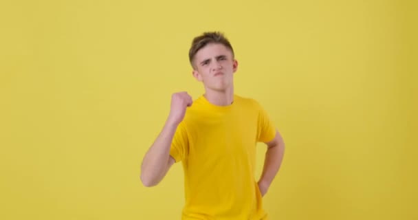 Sarı tişörtlü adam sarı arka planda dans ediyor. — Stok video