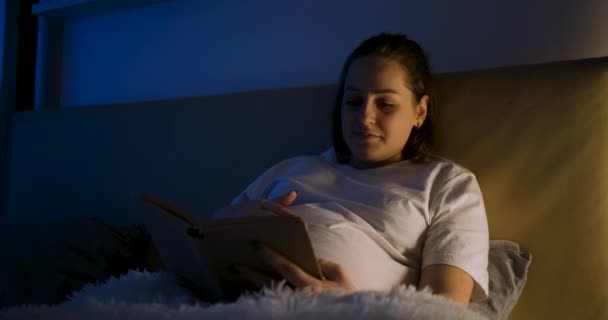 Pregnant woman using phone in bed at home — Stock Video