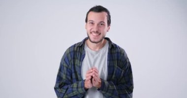 Adam ellerini ovuyor ve kameraya bakıp gülümsüyor.