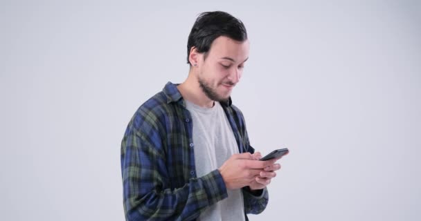 Hombre guapo mensajería de texto en el teléfono móvil sobre fondo blanco — Vídeo de stock