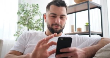 Koltukta akıllı telefon kullanan orta yaşlı bir adam. 