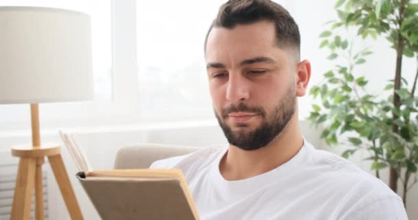 Homem lendo um livro em casa — Vídeo de Stock
