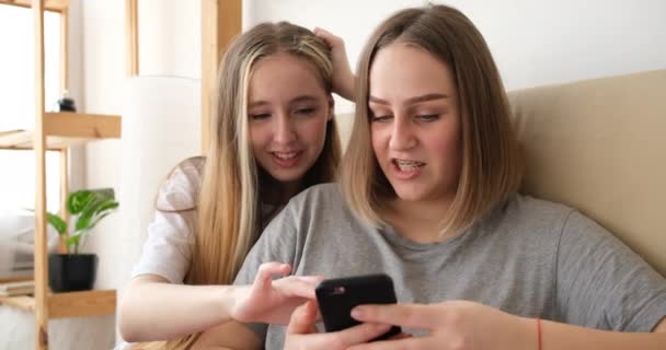 LGBT paar met behulp van mobiele telefoon liggend op bed thuis — Stockvideo