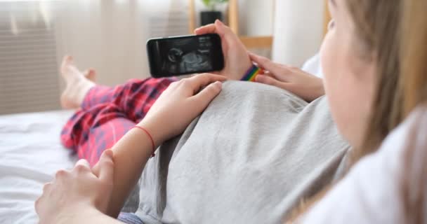 Dwie kobiety patrzące na USG przyszłego dziecka na smartfonie — Wideo stockowe