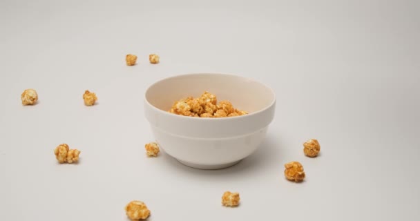 Palomitas de maíz caramelizadas que caen en una taza blanca, listas para comer — Vídeos de Stock